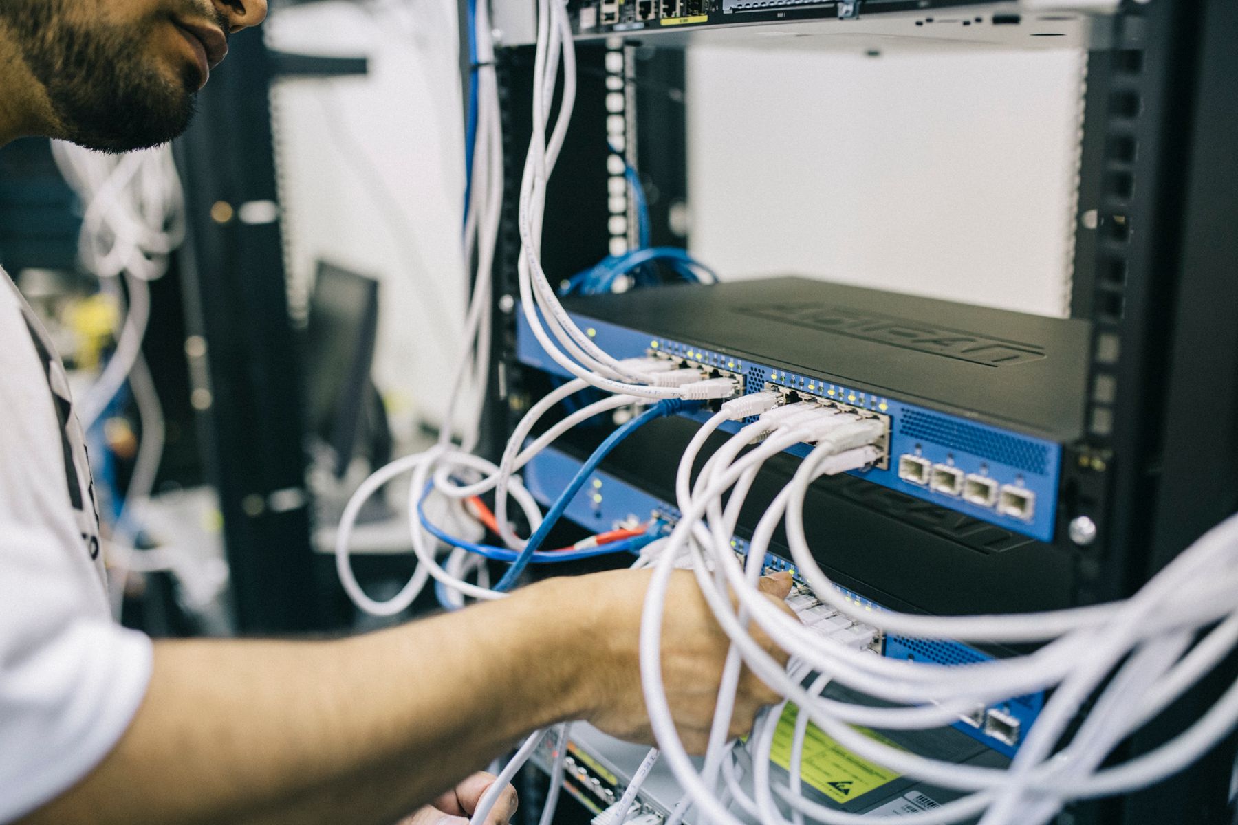 Field engineer connecting structured cabling to network switches